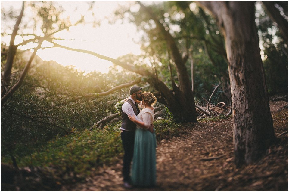 bride and groom eloped and embrace in the woods at sunset
