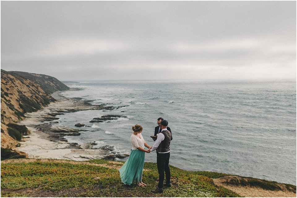 bride and groom exchange vows on a bluff overlooking the ocean